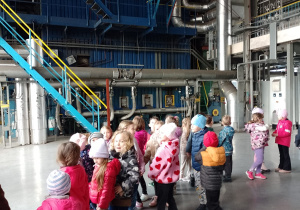 Dzieci stoją w budynku elektrociepłowni