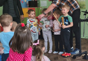 Muzyk pokazuje dzieciom, jak grać na instrumentach