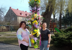 Dwie nauczycielki z palmą w ogrodzie