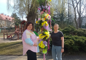 Dwie nauczycielki z palmą w ogrodzie