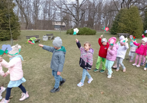 Dzieci idą z kwiatami w dłoniach