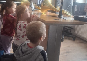 Dzieci patrzą na instrumenty leżące na biurku