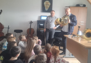 Muzyk opowiada dzieciom o instrumencie, a dzieci słuchają