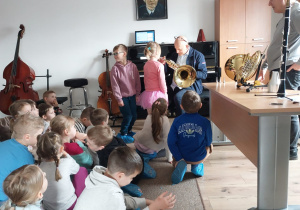 Nauczyciel szkoły pokazuje dziewczynce tubę