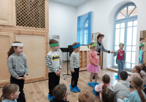 Kilkoro dzieci stoi z nauczycielką