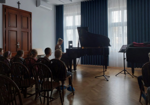 Dzieci słuchają gry na fortepianie