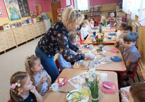 Pani Monika z grupy Mrówkirozkłada dzieciom babke