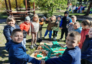 Dzieci stoją wokół ułożonego drzewa z rolek