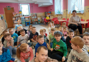 Wśród dzieci jedno ma na głowie czapkę maciejówkę