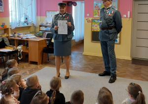 Pani pokazuje dzieciom obrazek do pokolorowania