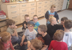 Wśród dzieci jedno ma na głowie czapkę maciejówkę