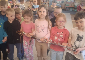 Kilkoro dzieci trzyma szablę