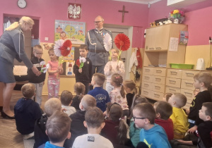 Kilkoro dzieci trzyma w rękach kwiaty w barwach narodowych