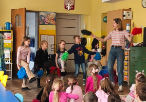 Kilkoro dzieci przekłada pompony pod kolanem