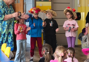 Kilkoro dzieci w kapeluszach gra na instrumentach