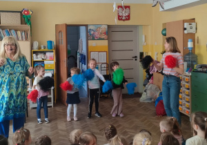 Czworo dzieci tańczy z pomponami