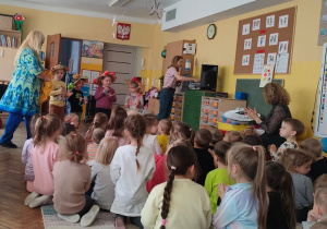 Czworo dzieci w kapeluszach gra na instrumentach