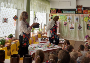 Pani Wiesia pokazuje dzieciom koszyk z jabłkami