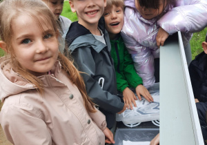 Kilkoro dzieci rysuje palcem na tackach z solą