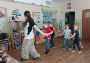 Kilkoro dzieci naśładuje ruchy tancerki