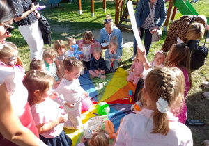 Grupa dzieci z animatorką podczas robienia stworkówz balonów