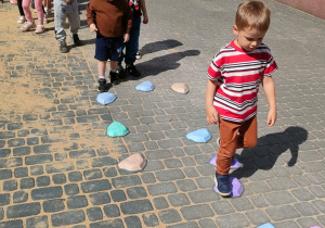 Dzieci przechodzą po krążkach sensorycznych