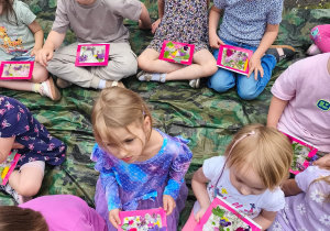 Dzieci pokazują swoje obrazki z roślin
