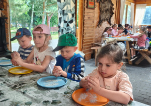 Czworo dzieci z grupy Biedronki formują ciasto chlebowe