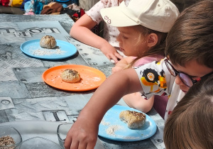 Dzieci z grupy Biedronki posypują uformowane chlebki