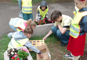 Dzieci z wolontariuszem przy stacji w kodowanie
