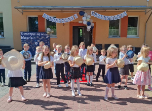 Dzieci z kapeluszami podczas śpiewania piosenki