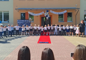 Dzieci i panie trzymają się za ramiona