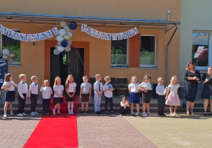 Dzieci stoją z paniami