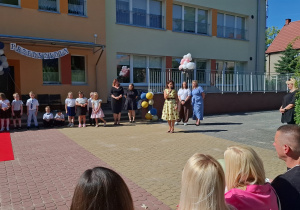 Pani dyrektor mówi do rodziców, obok stoją panie i dzieci
