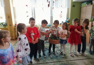 Dzieci w kole podają sobie jesienny kosz