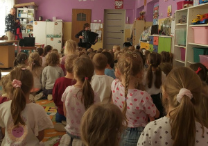Dzieci słuchają gry na akordeonie