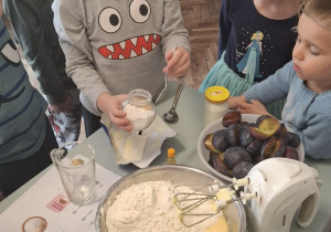Chłopiec wsypuje cukier do miski