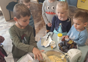 Chłopiec wsypuje cukier do miski