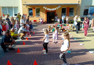 Kilkoro dzieci ześłiwką na łyżce idzie slalomem do rodziców