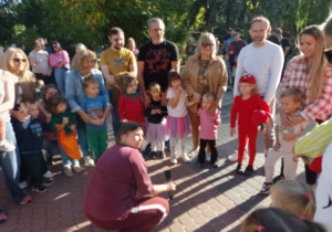 Kilkoro dzieci z opiekunami rozwiązują zagadki