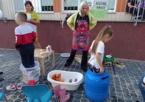 Dwoje dzieci ugniata kapustę w beczce