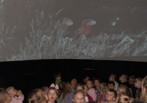 Dzieci oglądają film edukacyjny w kopule projekcyjnej