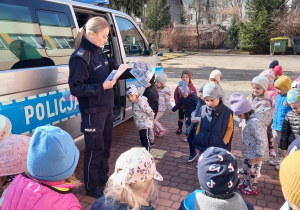 Dzieci z grup: I, II i III słuchają opowiadania czytanego przez panią policjant