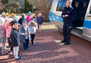 Dzieci grup młodszych słuchają pani policjant
