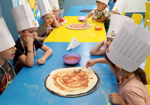 dzieci dekorują pizze