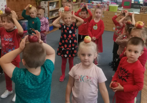 Dzieci z grupy w zabawie z jabłkami na głowie