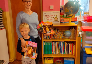 Emil z grupy V i jego mama z książkami przy kąciku czytelniczym